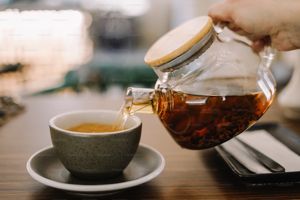 a person pours tea into a cup