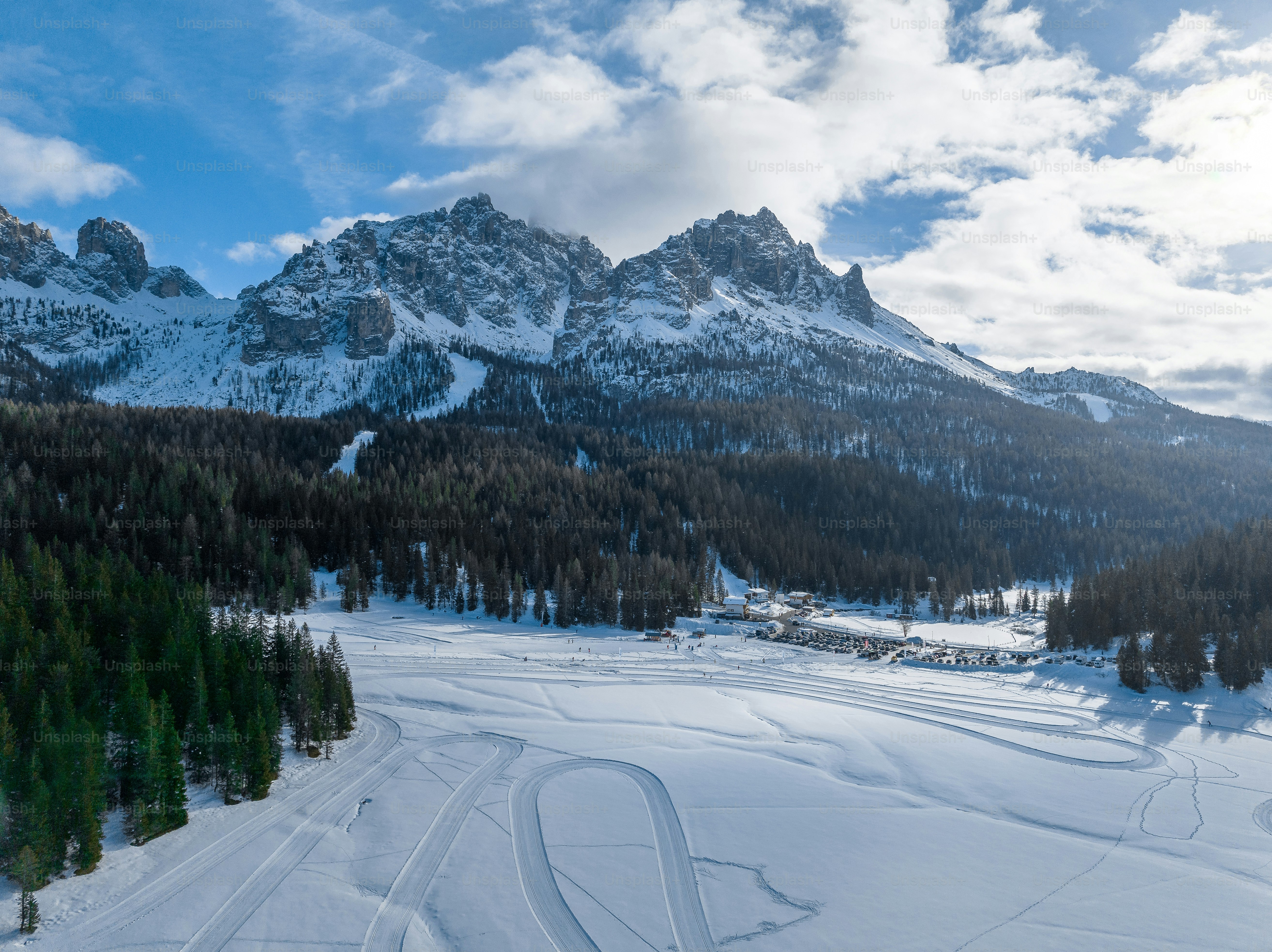 gunung yang tertutup salju dengan jalur ski di latar depan