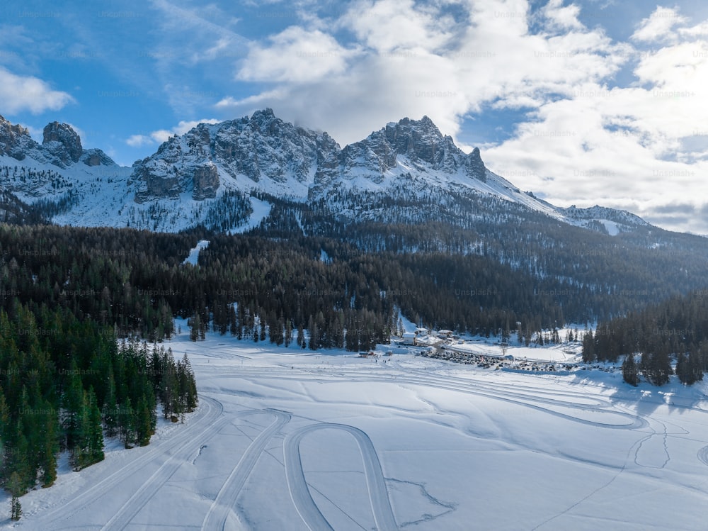 une montagne enneigée avec une piste de ski au premier plan