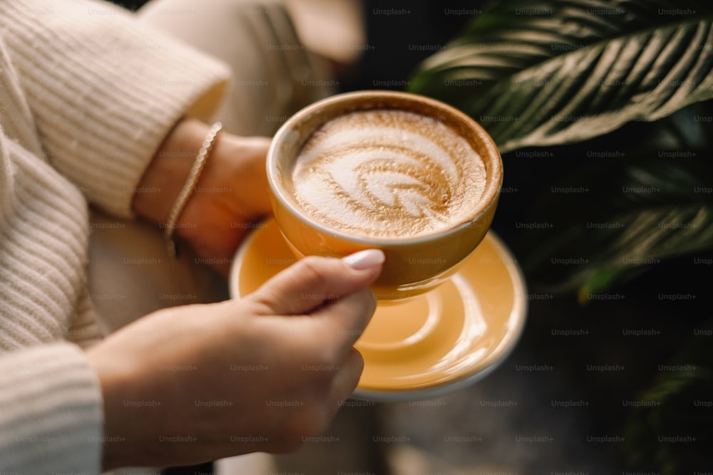 une personne tenant une tasse de café à la main