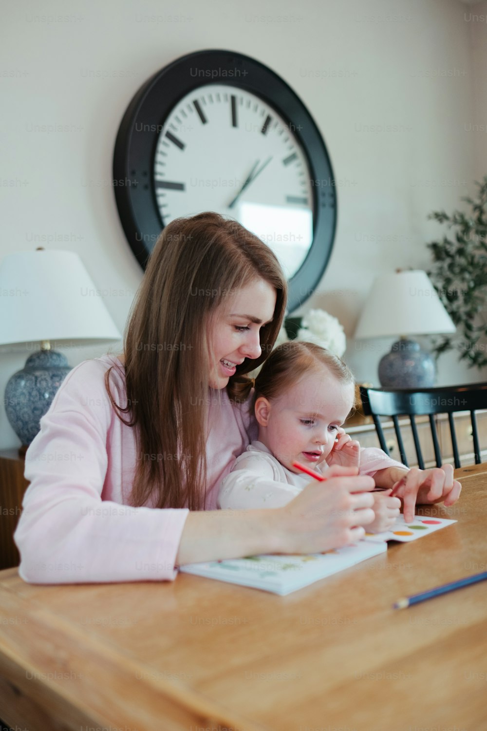 a woman sitting at a table with a child