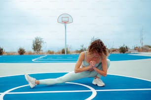 a woman is sitting on a basketball court