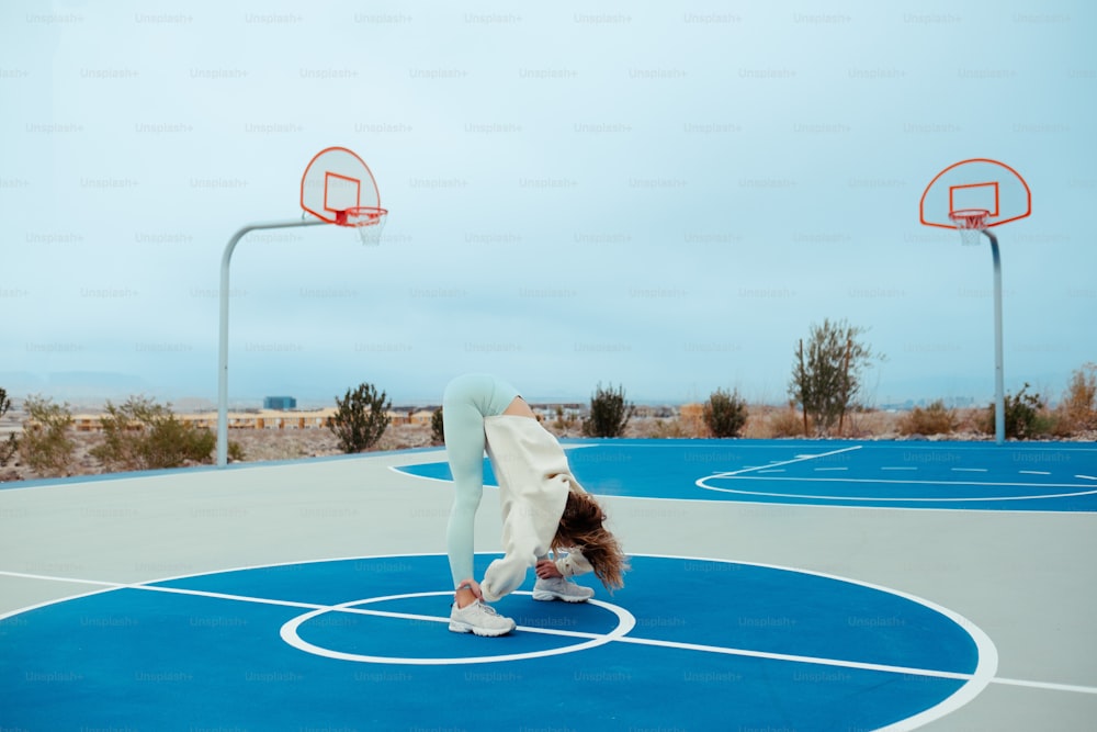 a person is doing a handstand on a basketball court