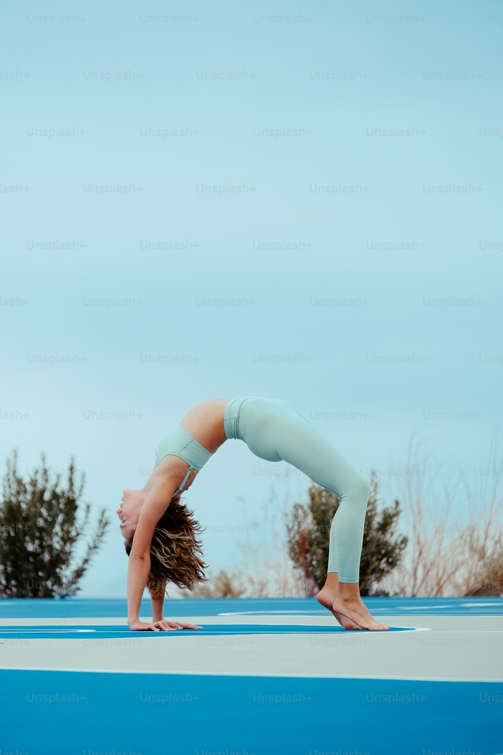 a woman doing a handstand on a yoga mat