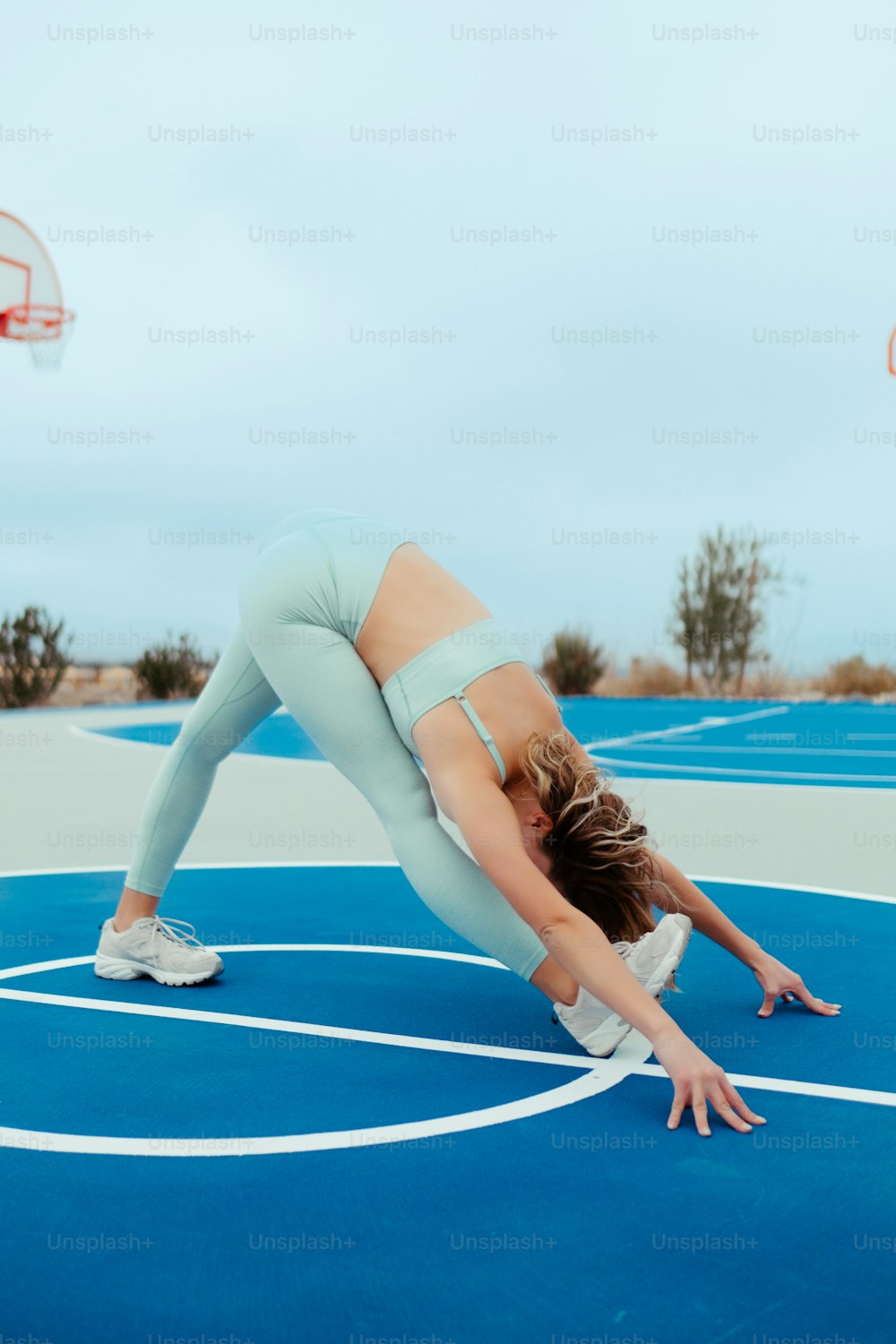 a woman is doing a handstand on a basketball court