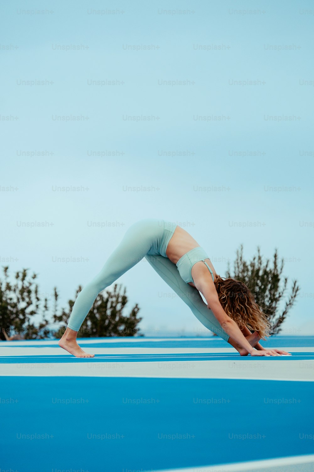 a woman doing a handstand on a blue surface
