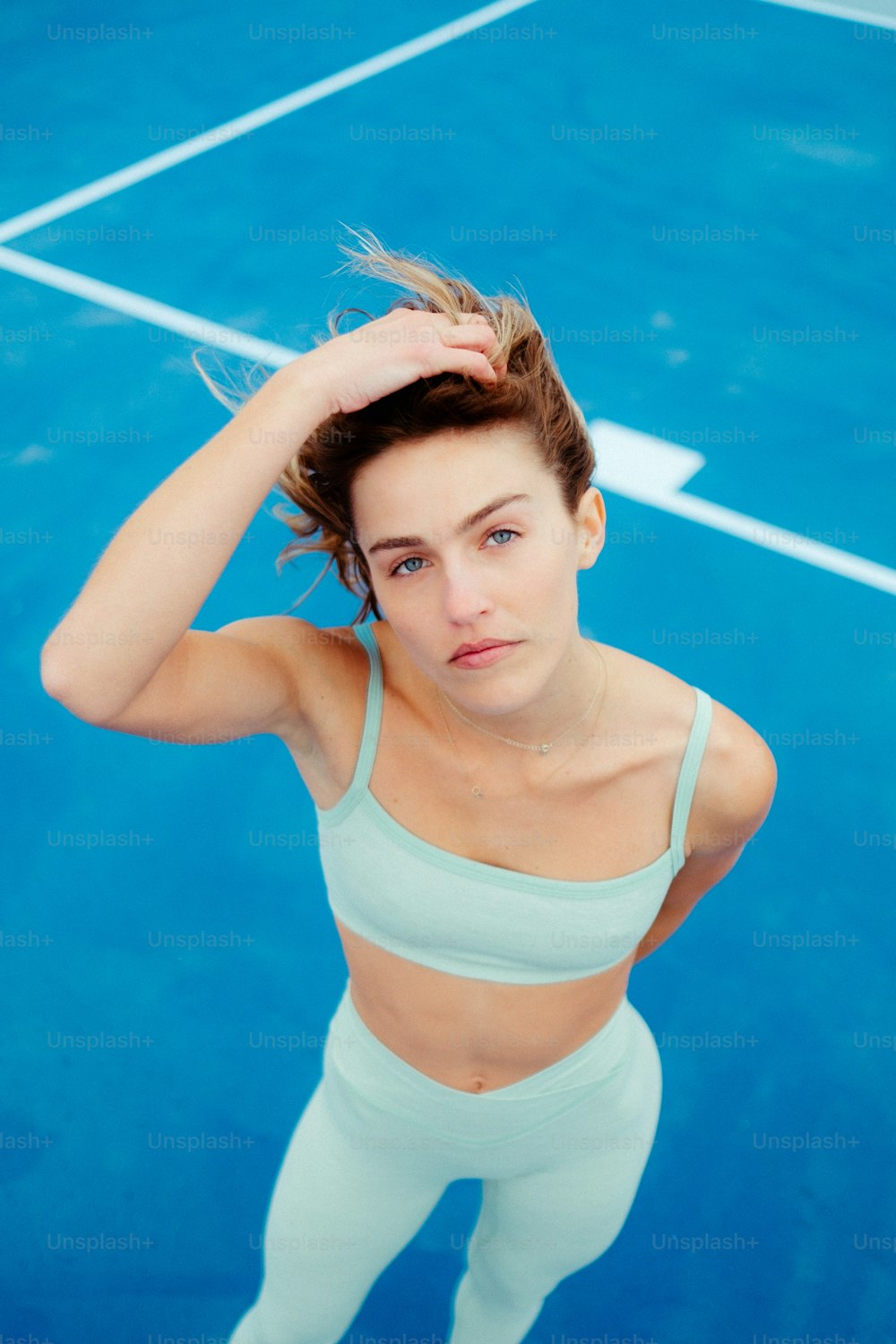 a young woman holding a tennis racquet on top of a tennis court