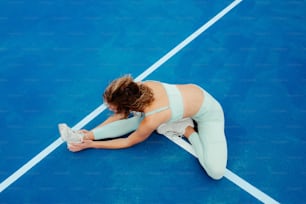 una donna seduta su un campo da tennis con in mano una racchetta da tennis