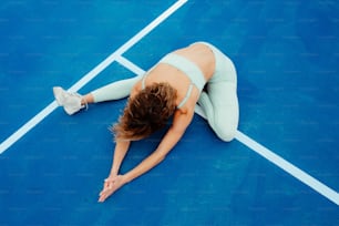 Una donna è sdraiata su un campo da tennis