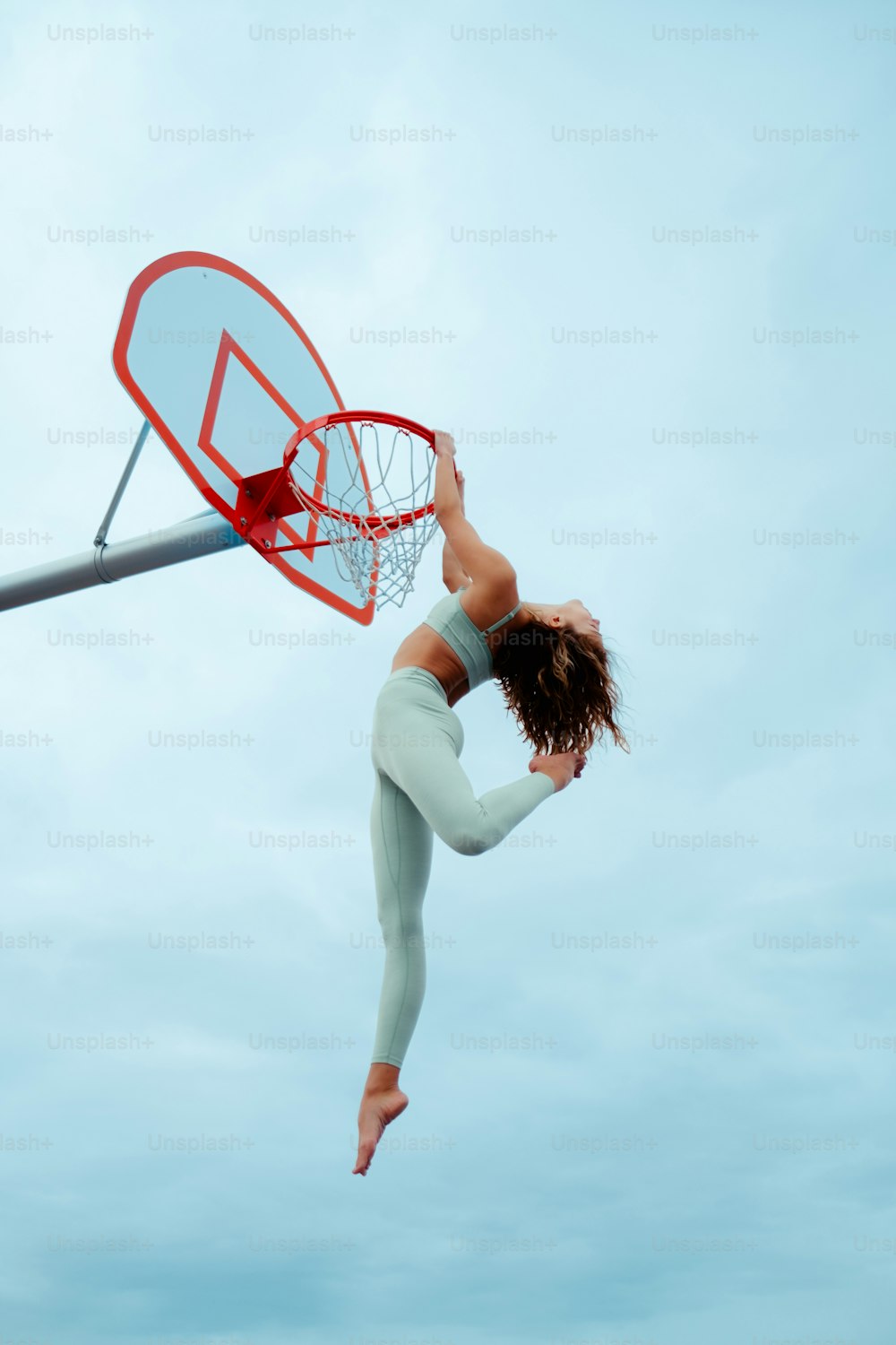 농구공을 덩크하기 위해 공중으로 뛰어오르는 여자