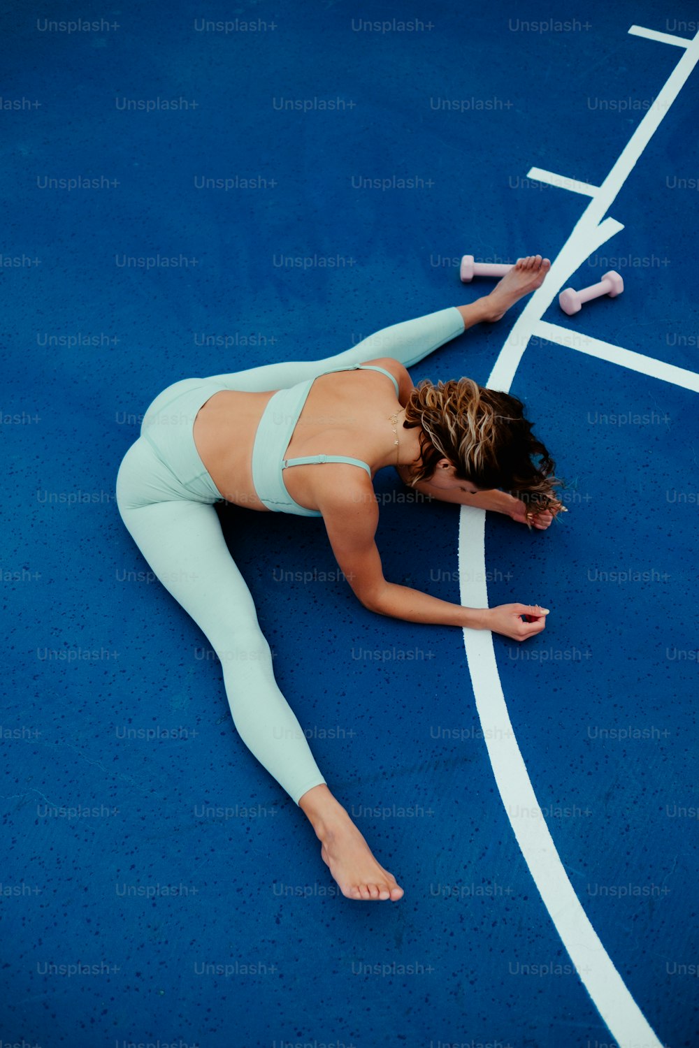 a woman is laying on a tennis court