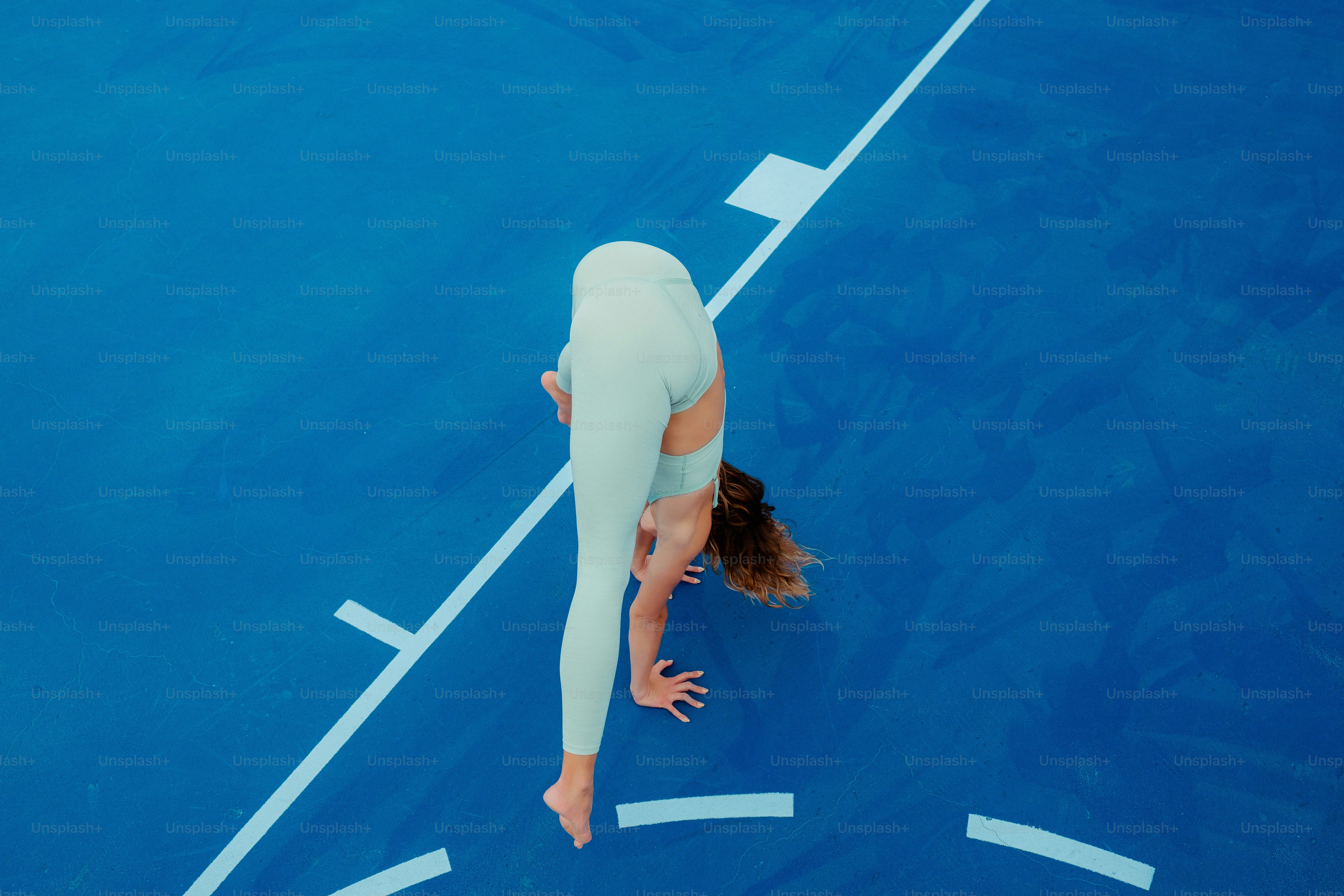 Una donna in un vestito bianco è su un campo da tennis blu