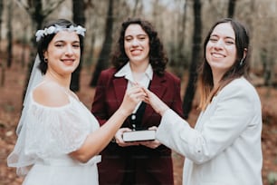 a bride is putting a ring on her friend's finger