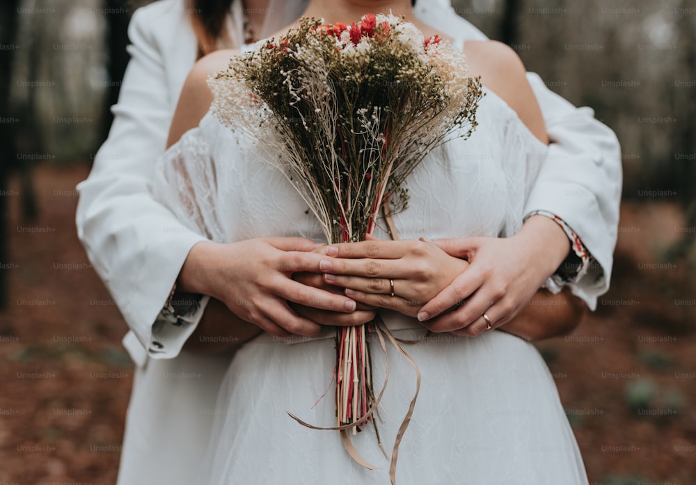 a bride and groom holding a bouquet of flowers
