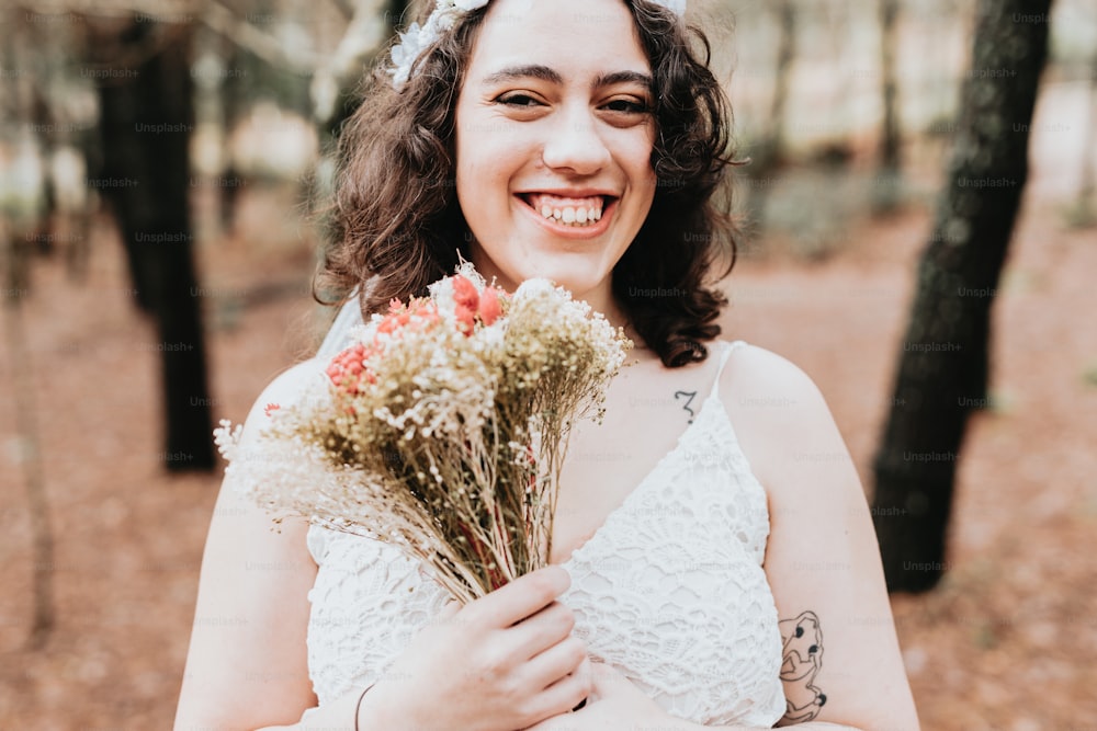 uma mulher em um vestido branco segurando um buquê de flores