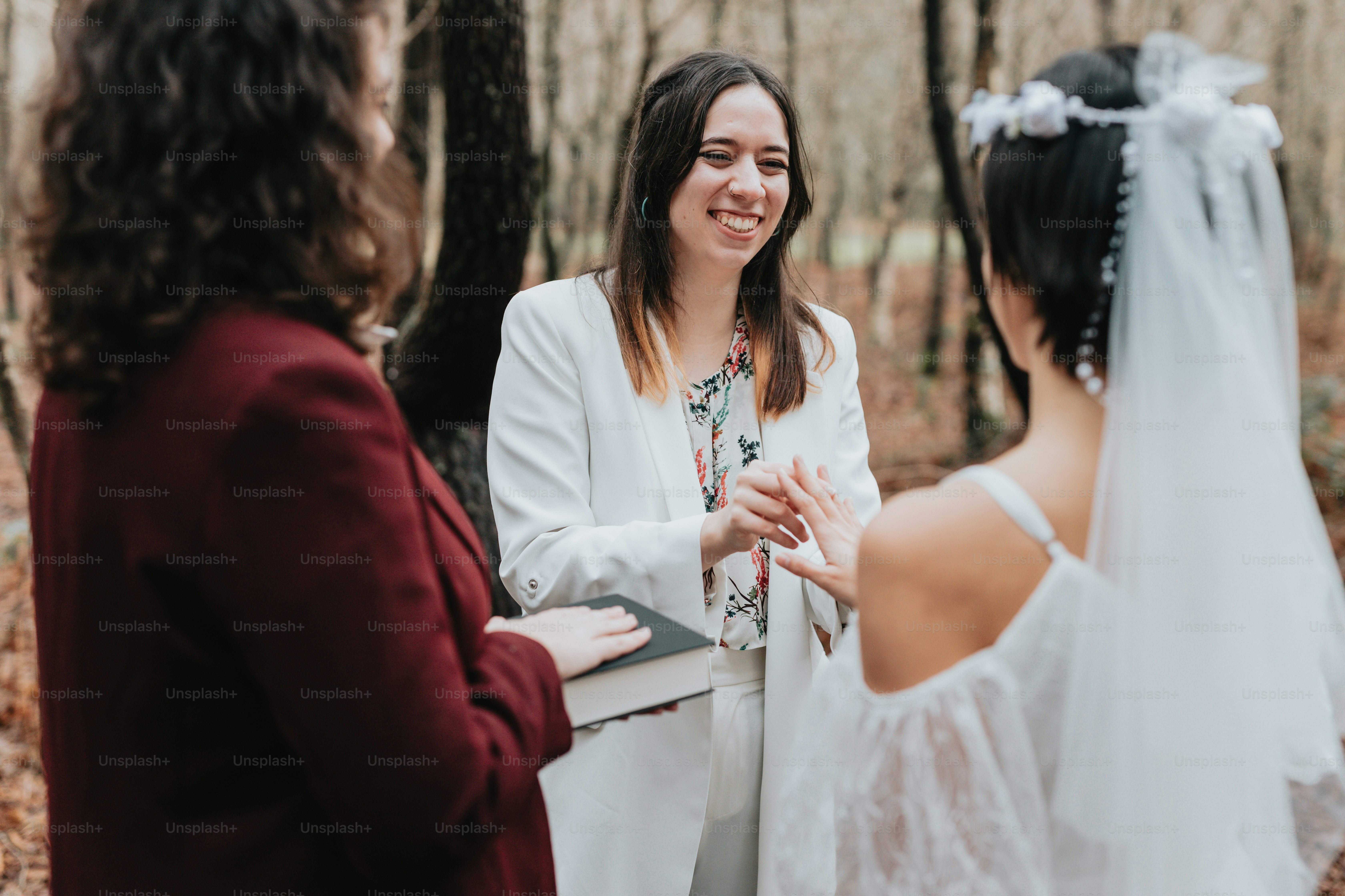 a woman standing next to another woman in a forest