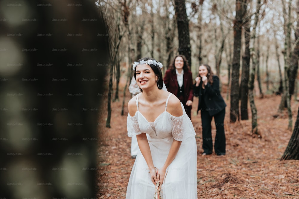 a woman in a wedding dress standing in the woods
