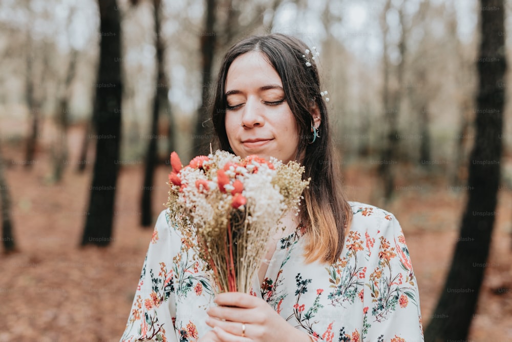 una donna che tiene un mazzo di fiori in una foresta