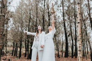 a couple of women standing next to each other in a forest