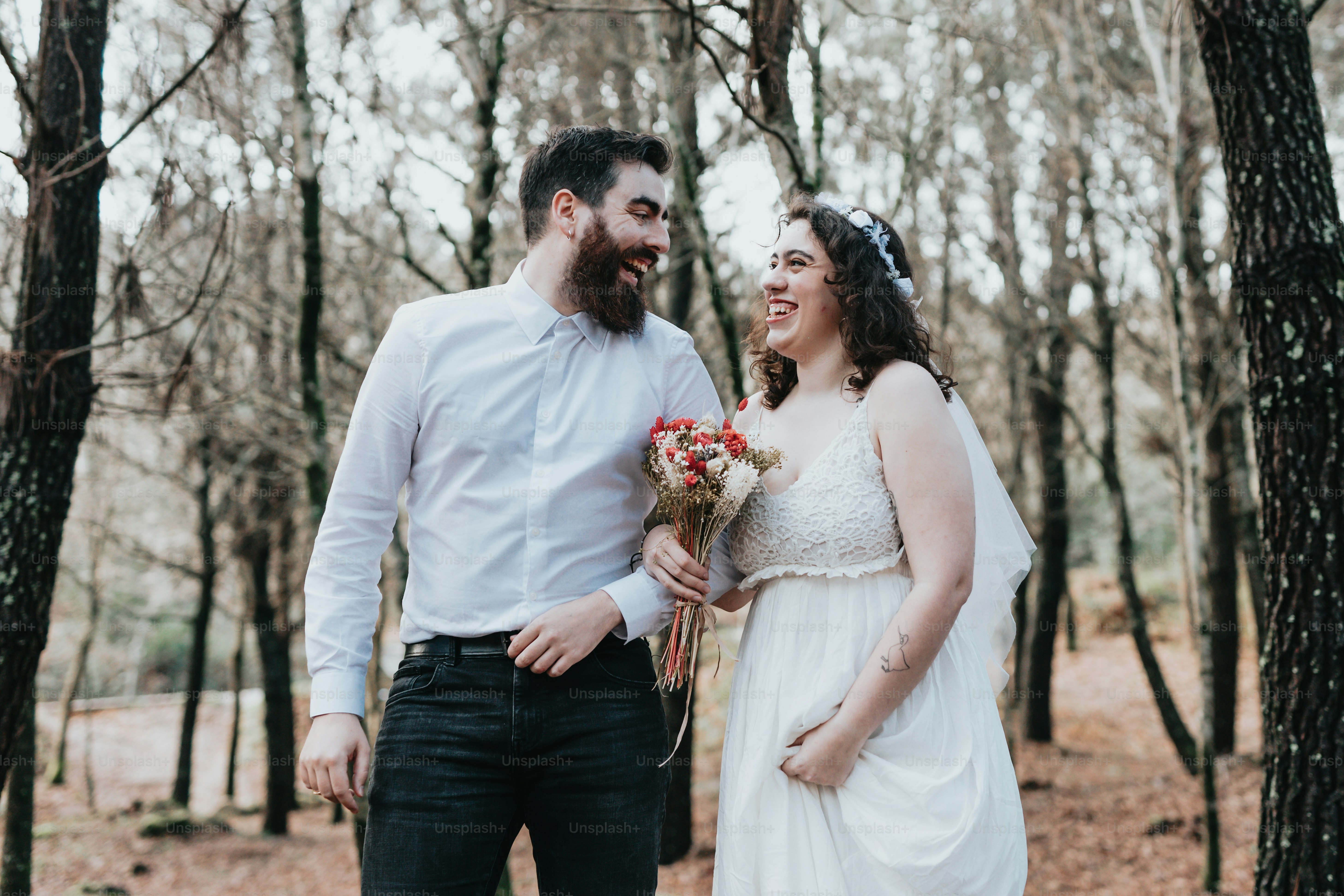 A man and a woman standing in the woods photo – Woodland wedding Image ...