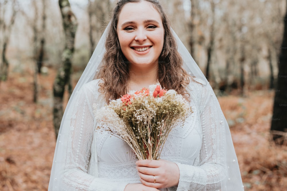uma mulher em um vestido de noiva segurando um buquê de flores