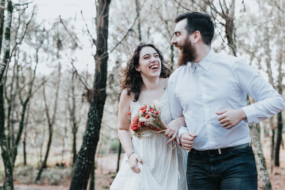 uma noiva e um noivo rindo na floresta