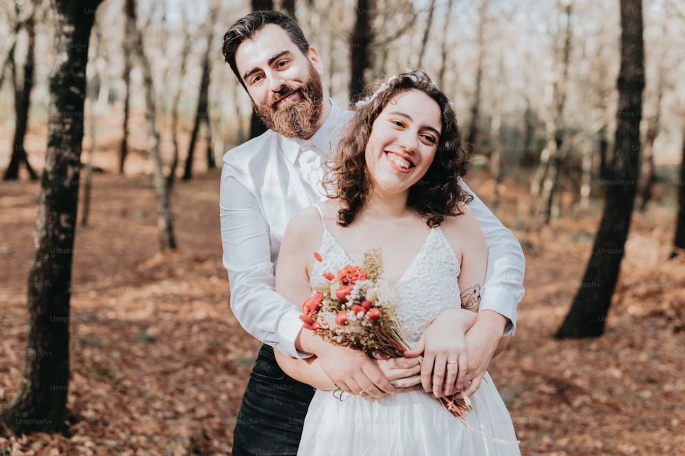 a bride and groom standing in the woods