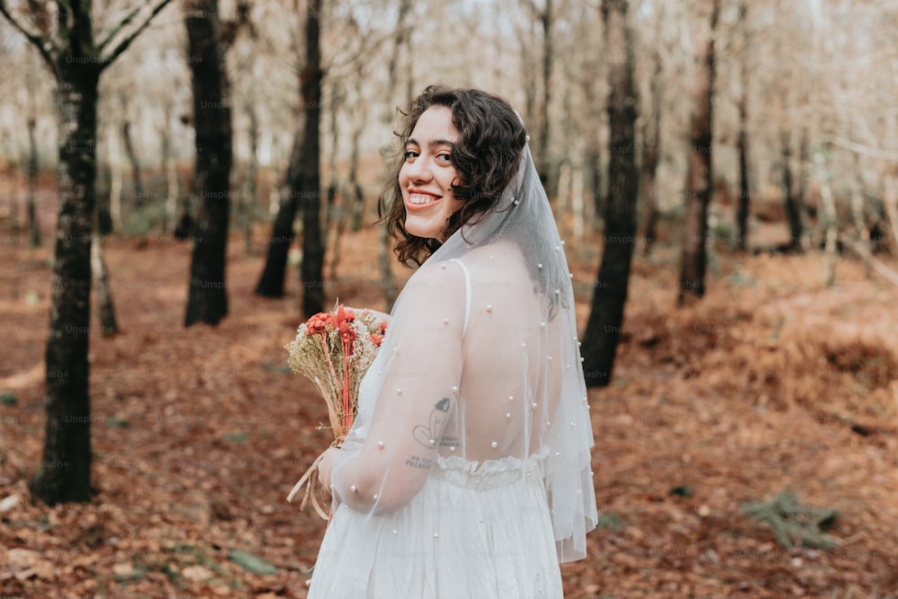 Una mujer con un vestido de novia sosteniendo un ramo de flores