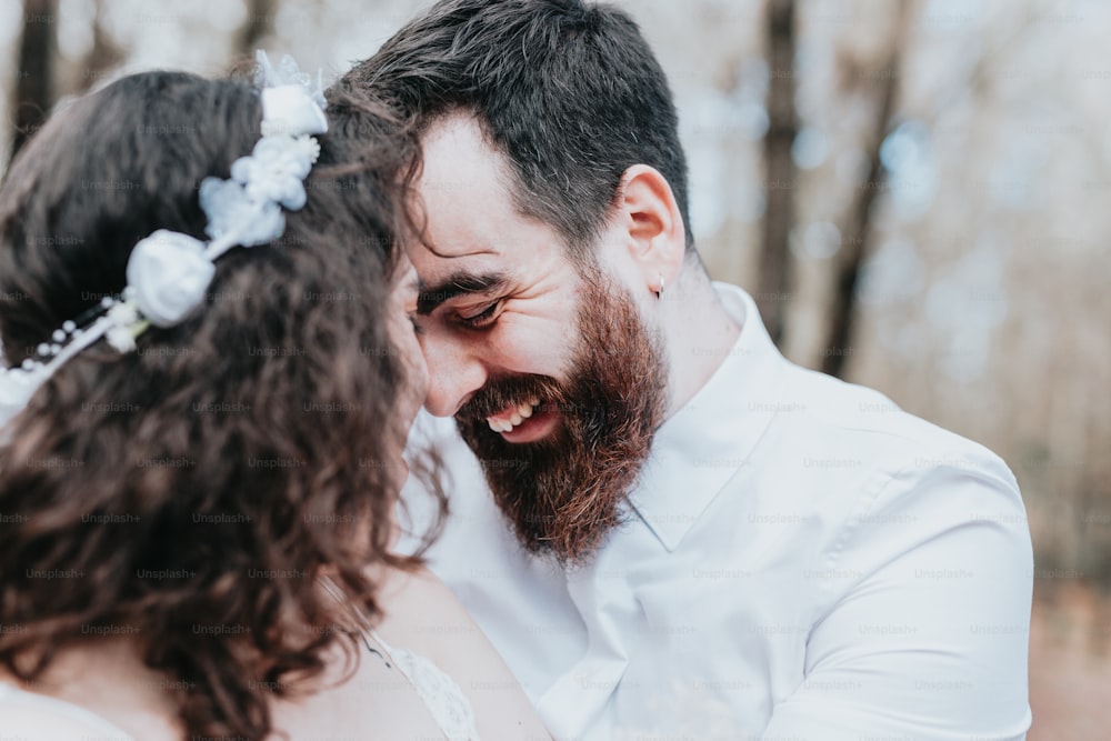 a bride and groom laughing together in the woods