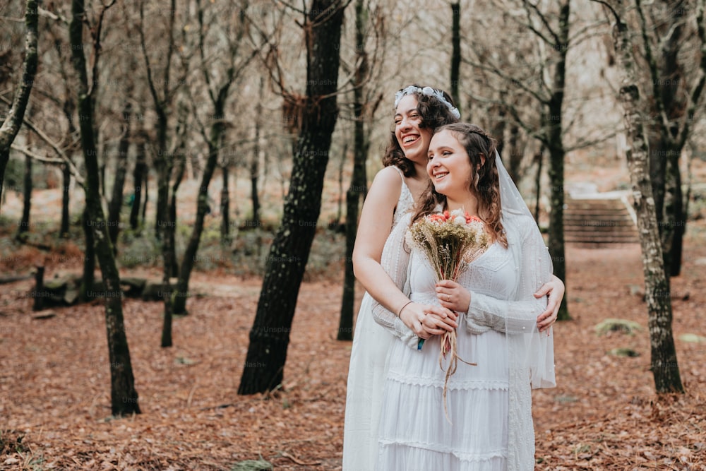 a couple of women standing next to each other in a forest