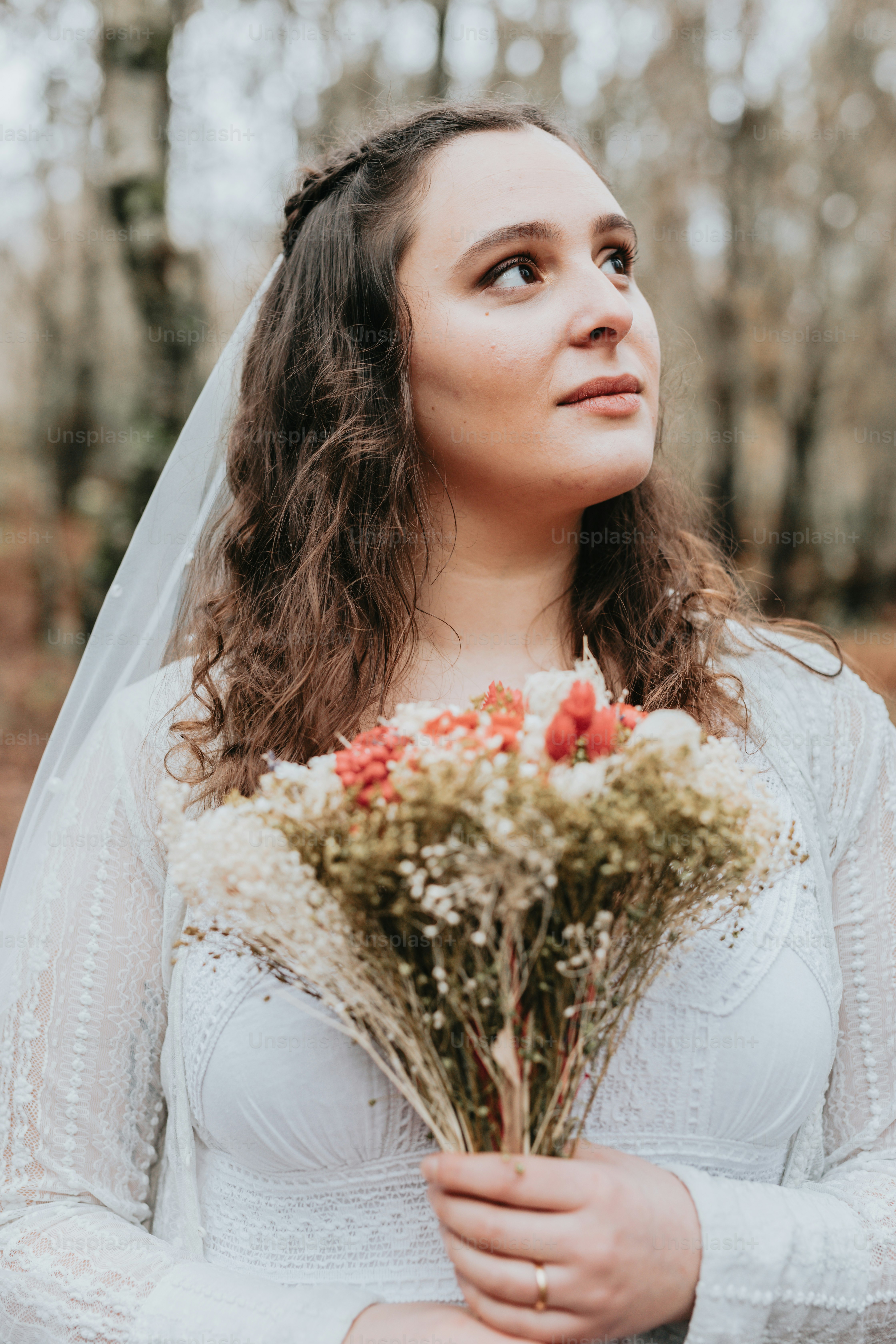 A woman in a wedding dress holding a bouquet of flowers photo – Bride ...