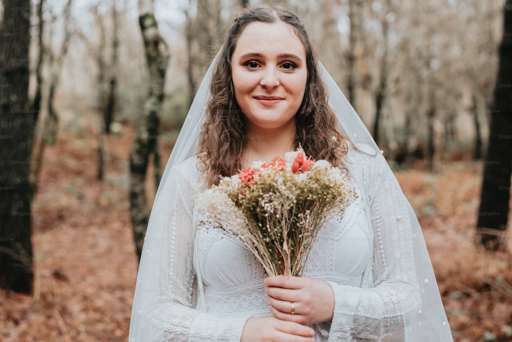 uma mulher em um vestido de noiva segurando um buquê de flores