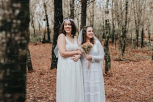 Una pareja de mujeres de pie una al lado de la otra en un bosque