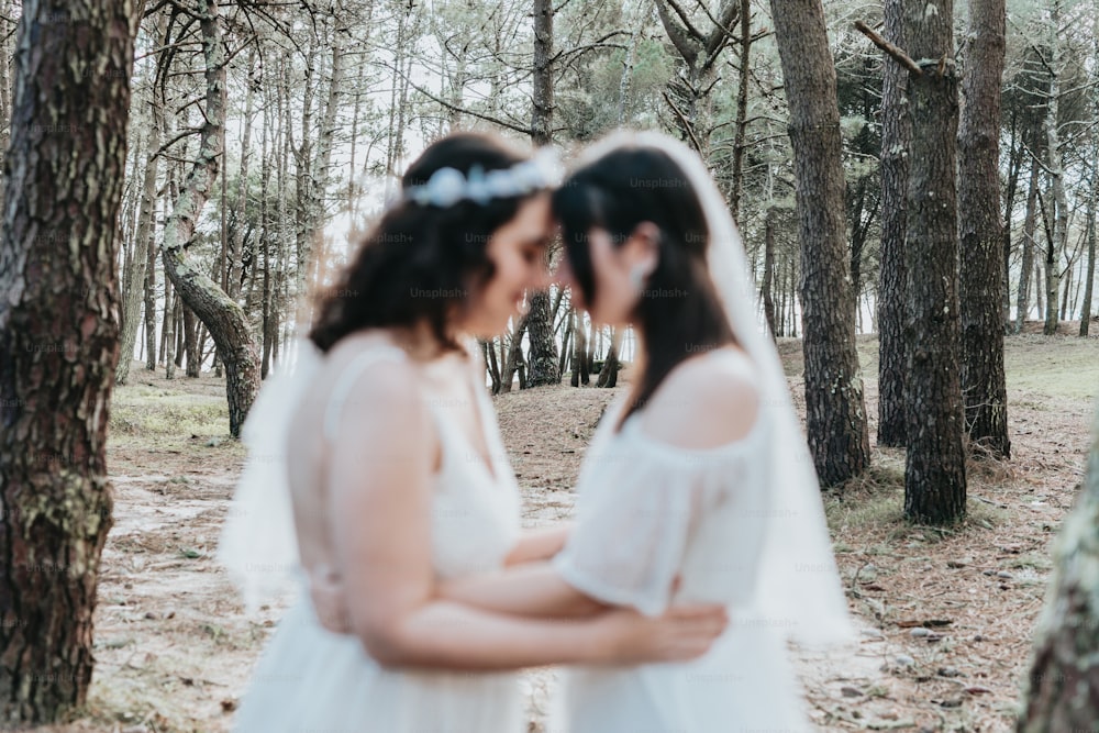 a couple of women standing next to each other in a forest