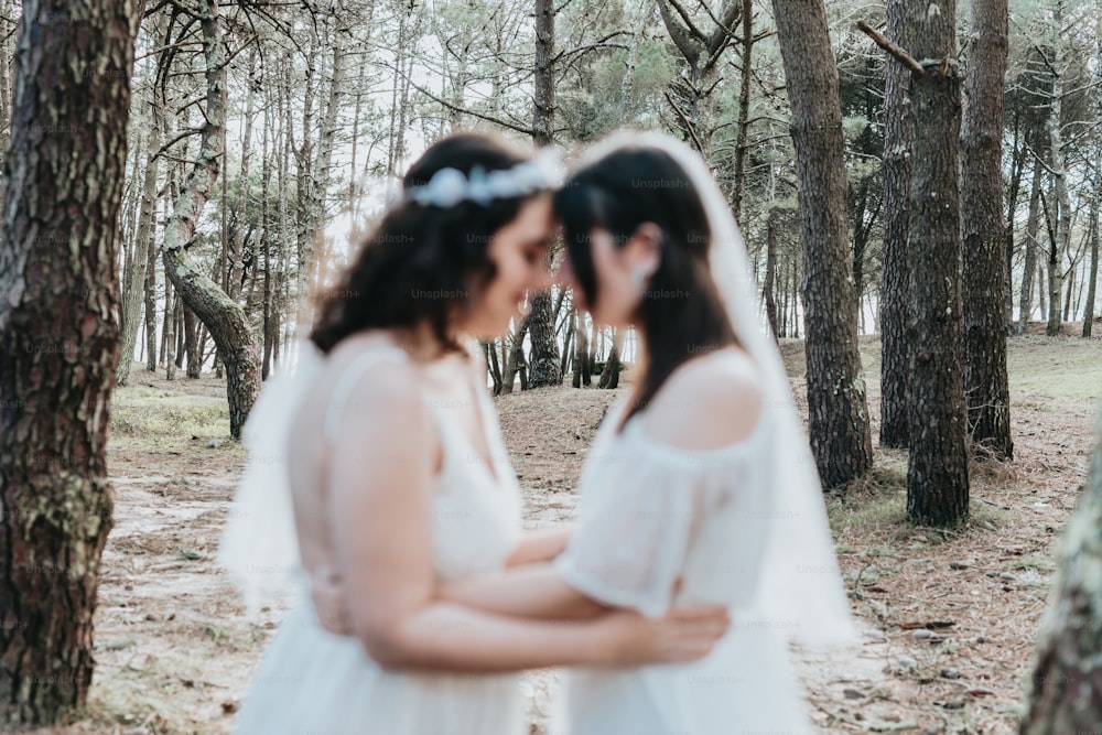 Una pareja de mujeres de pie una al lado de la otra en un bosque