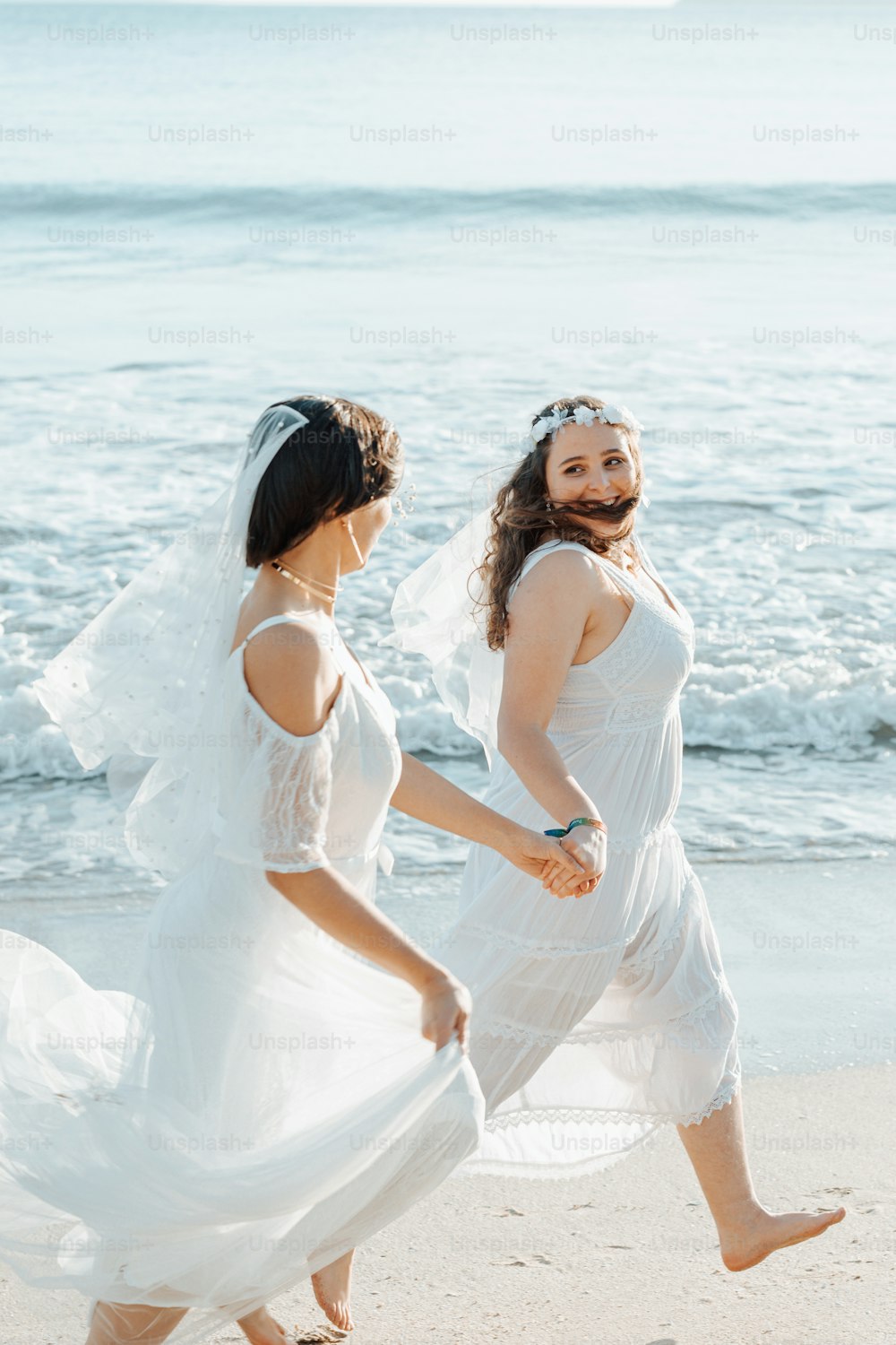 a couple of women walking on top of a beach