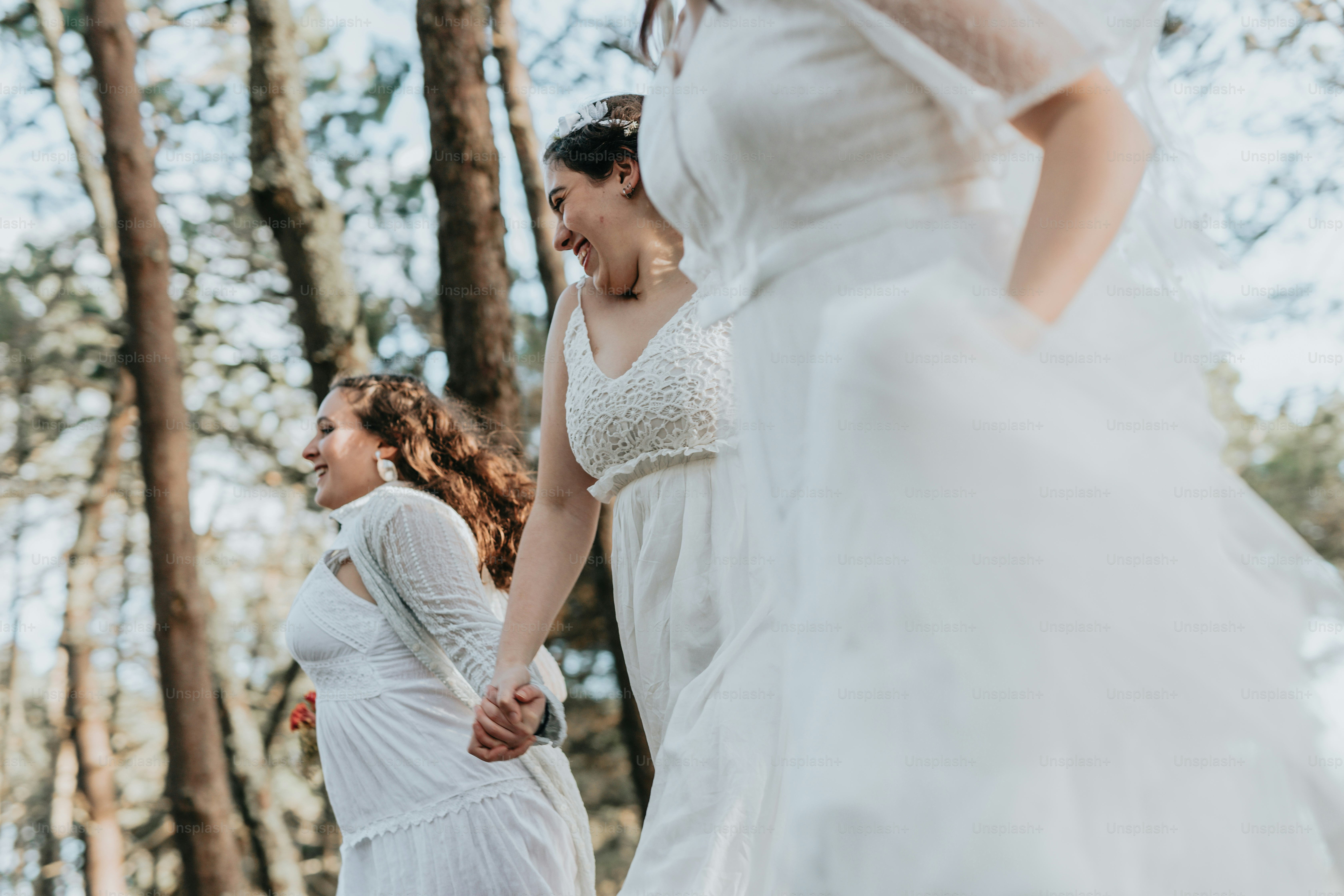 A group of women standing next to each other in a forest photo ...