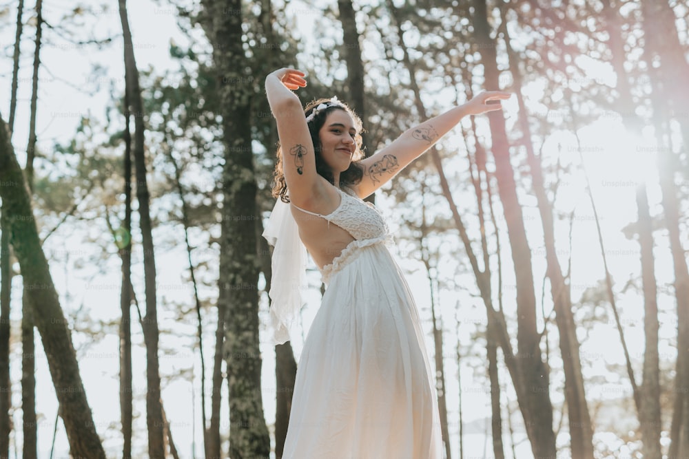 a woman in a white dress standing in the woods