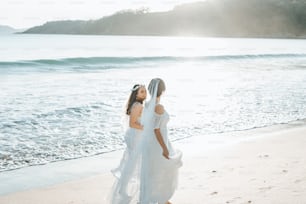 a couple of women standing on top of a beach