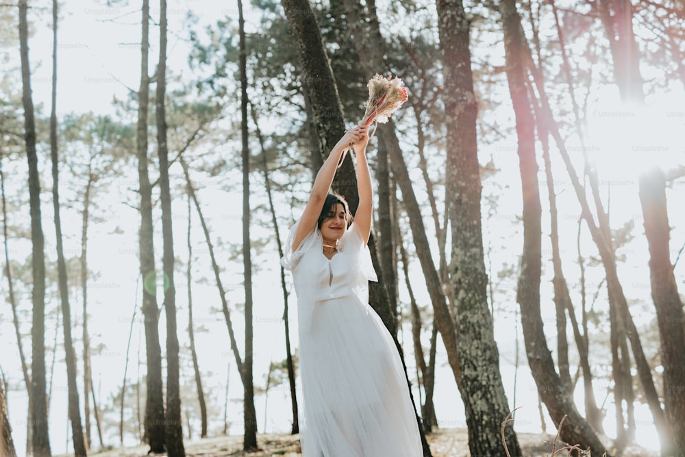 a woman in a white dress holding a frisbee in the air