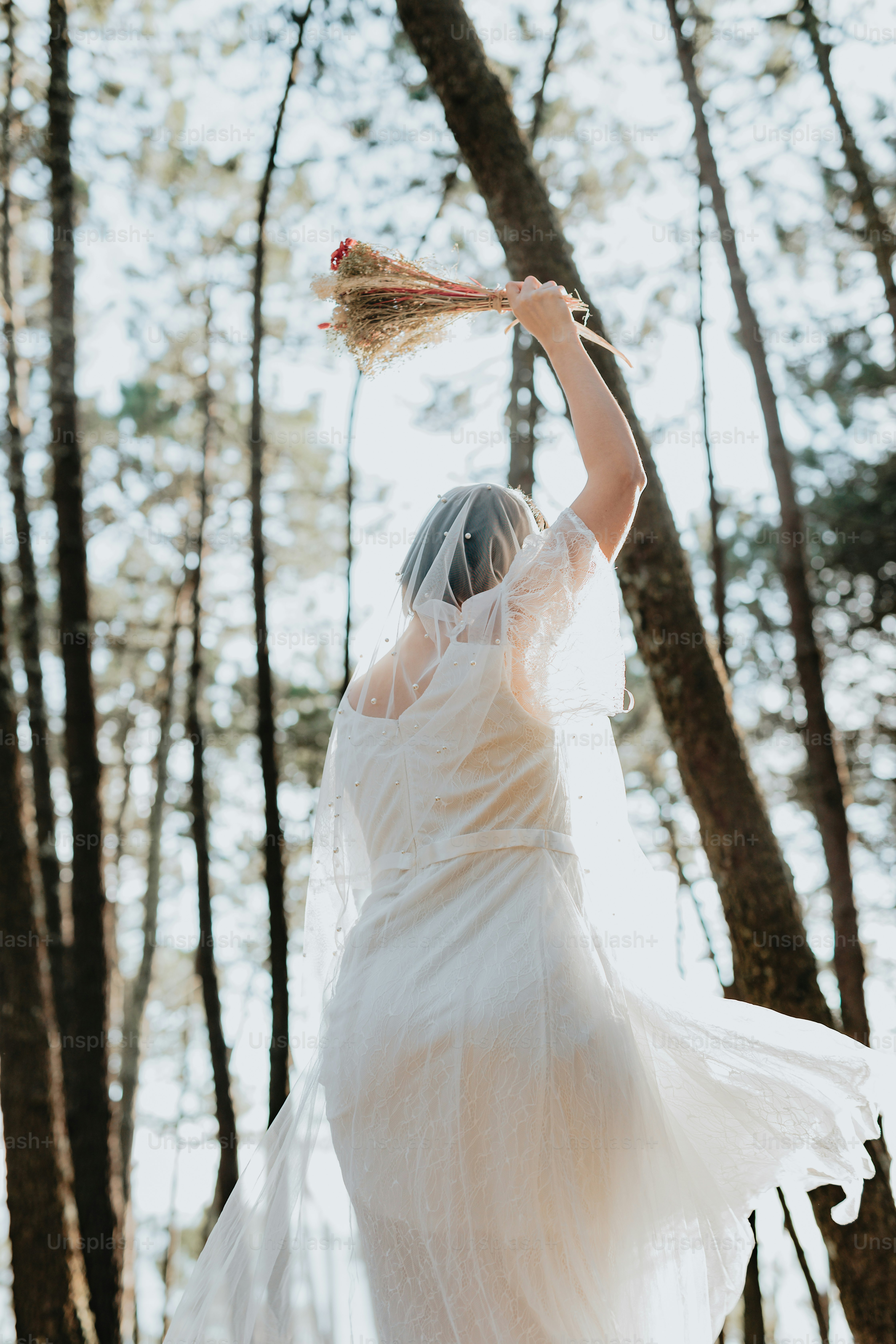 A woman in a white dress holding a bouquet of flowers photo – Get ...