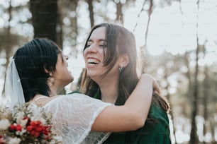 a bride hugging her friend in the woods