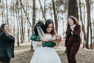 two women hugging each other in the woods