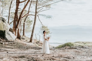 Una mujer con un vestido blanco parada en una playa