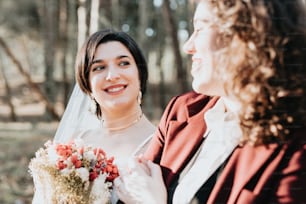 uma mulher segurando um buquê de flores ao lado de outra mulher
