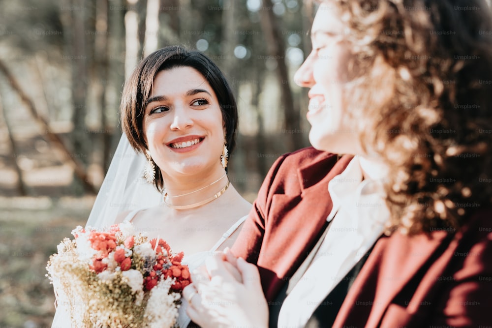 Una mujer sosteniendo un ramo de flores junto a otra mujer