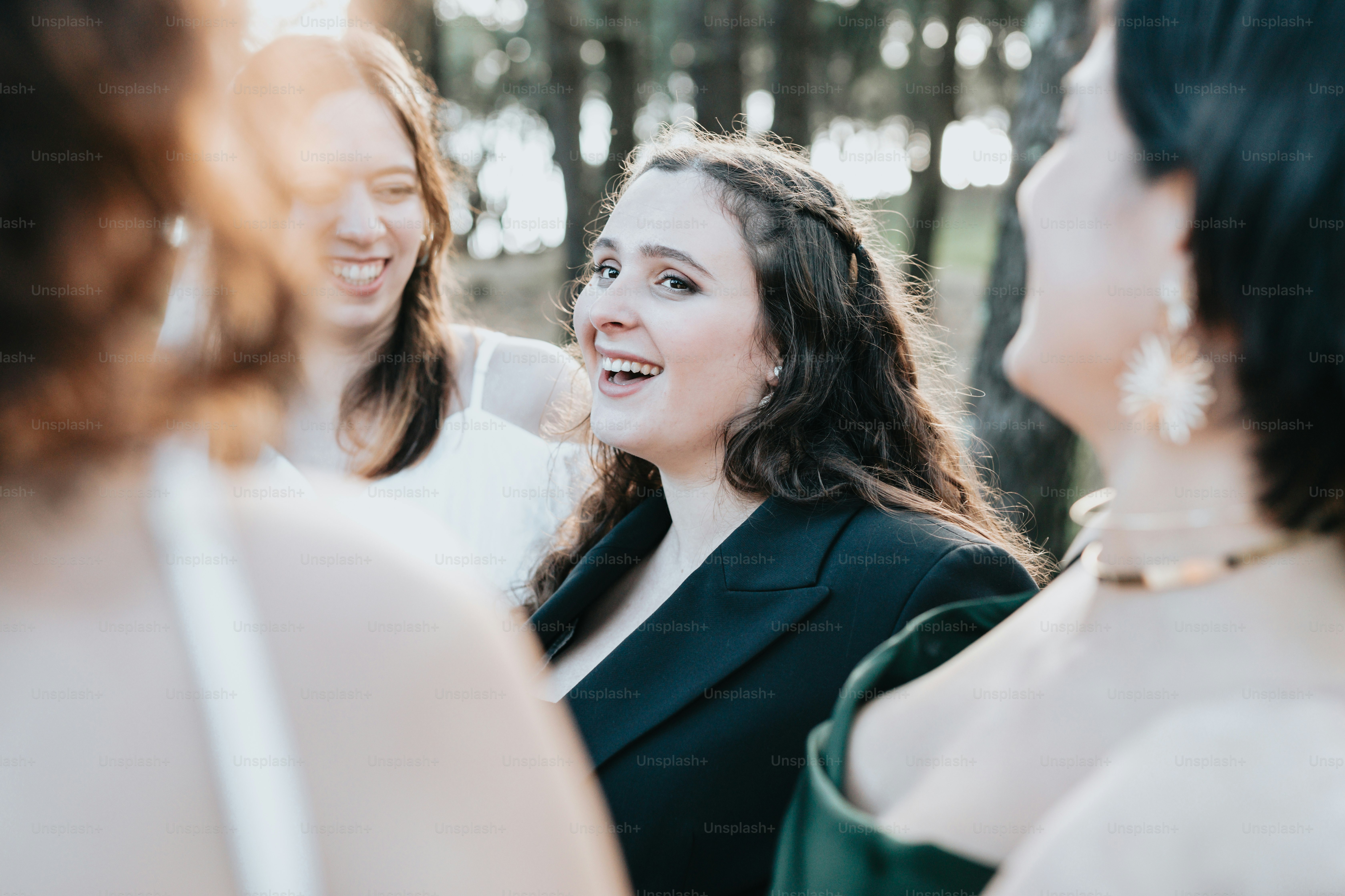 A group of women standing next to each other in a forest photo ...