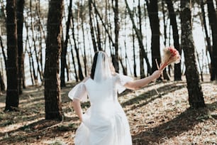 Une femme en robe blanche tenant un bouquet de fleurs