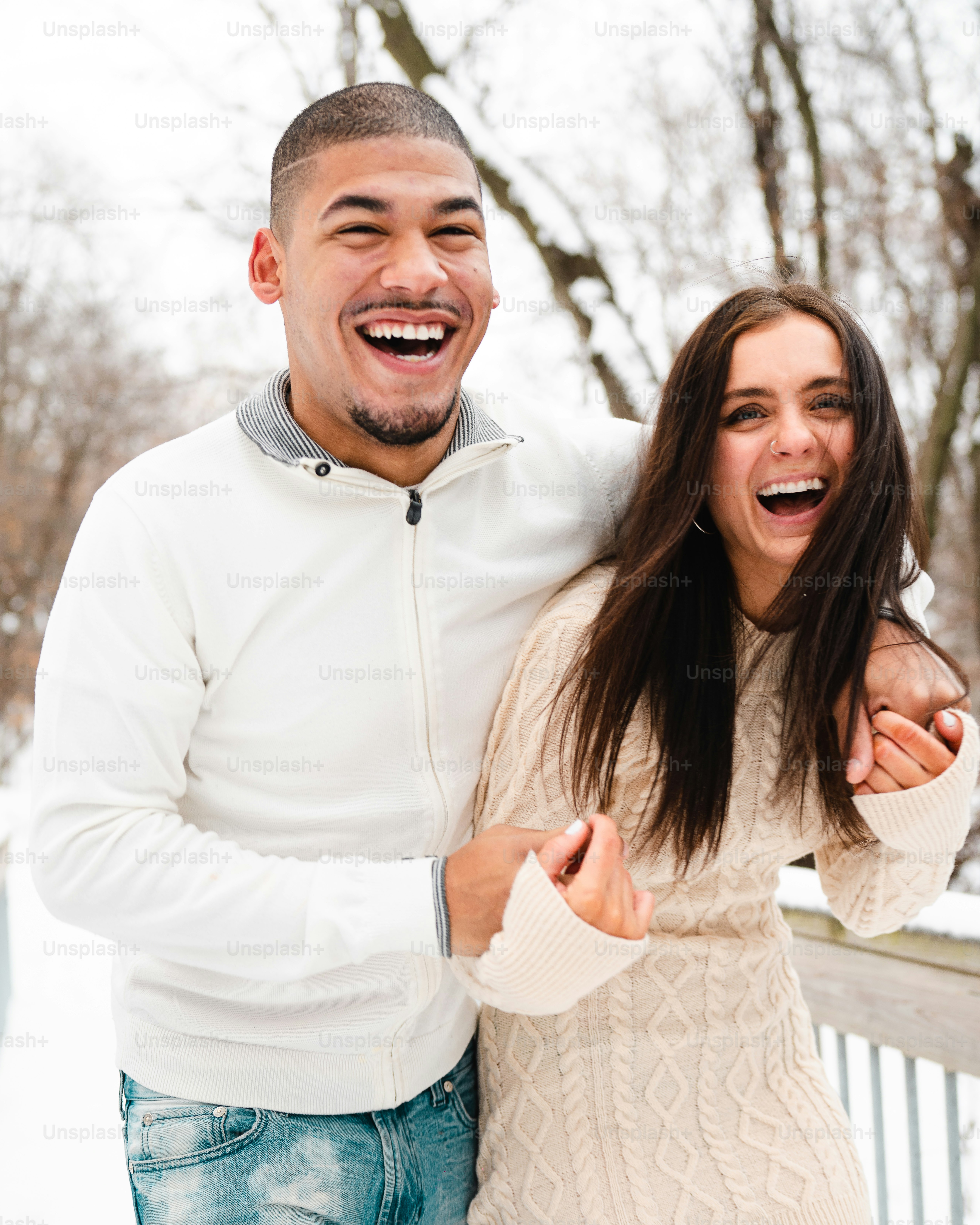 a man and a woman laughing in the snow