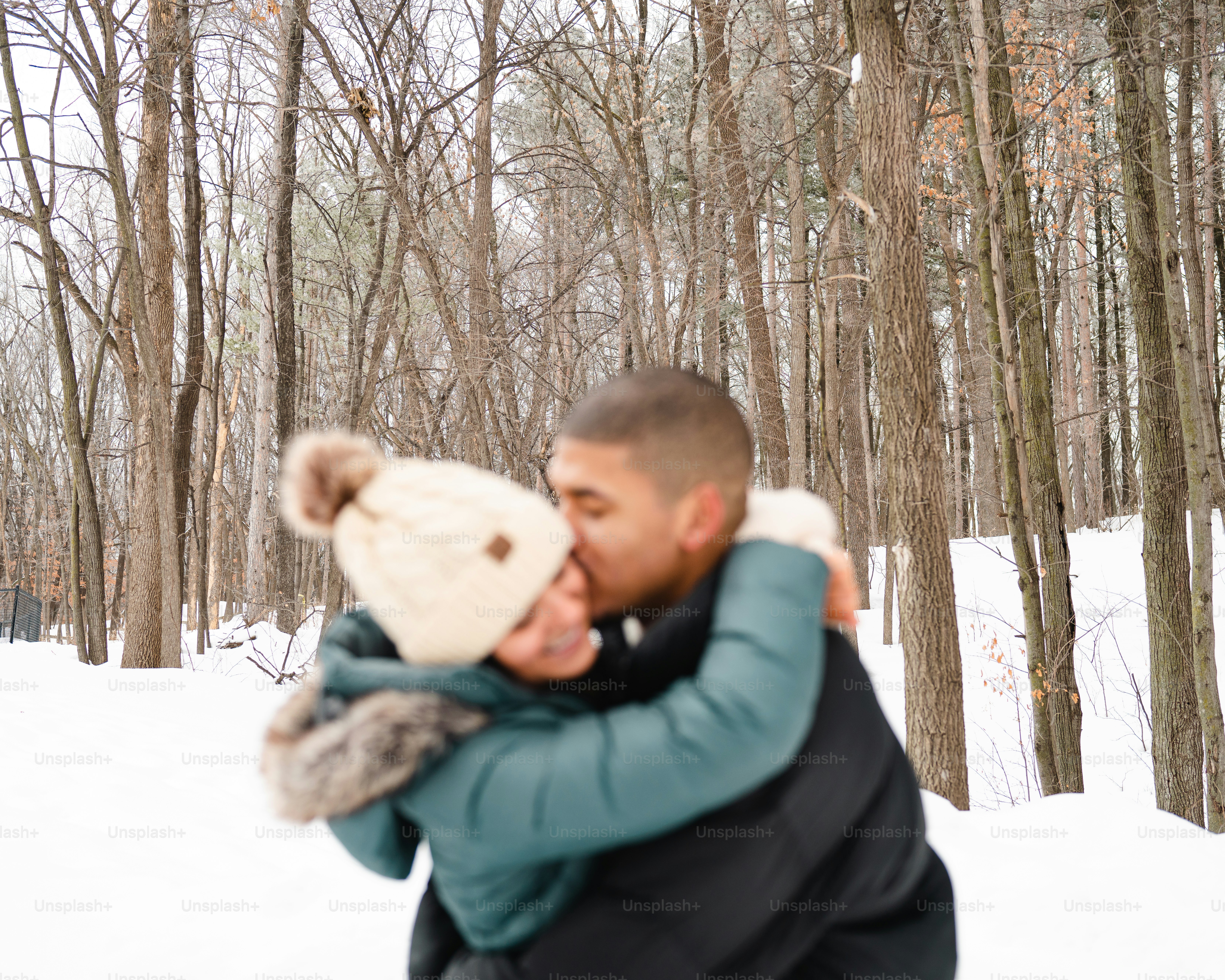 a man and a woman hugging in the snow